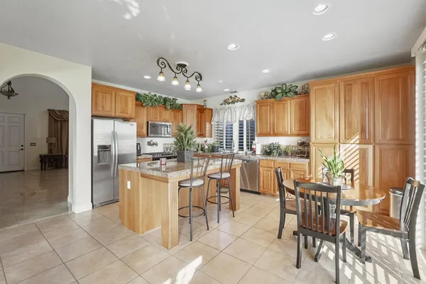 a kitchen with stainless steel appliances kitchen island granite countertop a refrigerator and cabinets