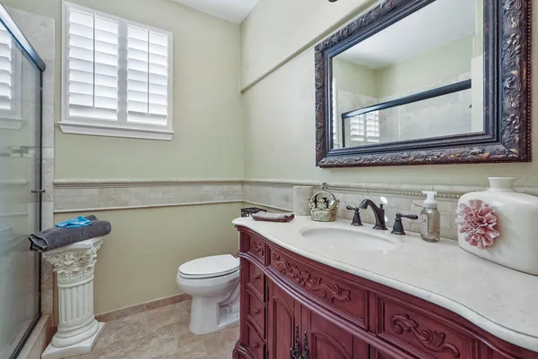 a bathroom with a granite countertop toilet sink and mirror