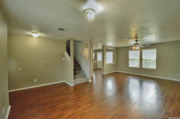 an empty room with wooden floor and windows