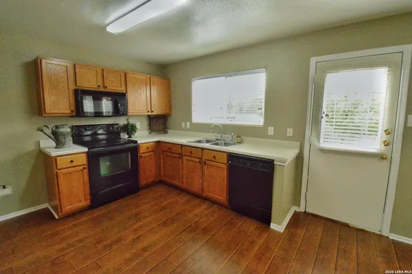 a kitchen with stainless steel appliances granite countertop wooden cabinets a stove top oven a sink and dishwasher
