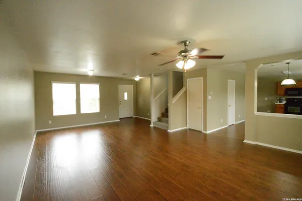 a view of an empty room with window and wooden floor