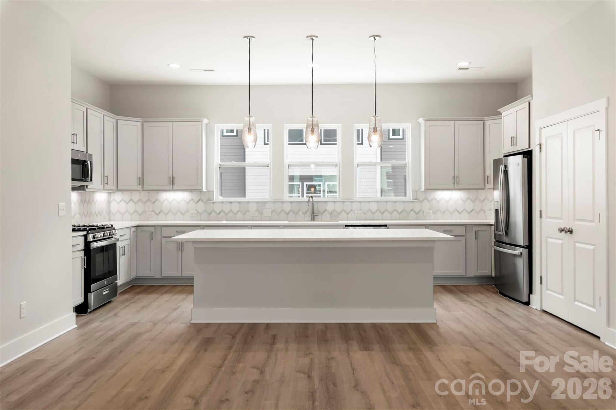 429 Nathaniel Way, Unit BRX0032 Charlotte, NC 28213 - Photo 2 of 43 a large white kitchen with kitchen island white cabinets and stainless steel appliances