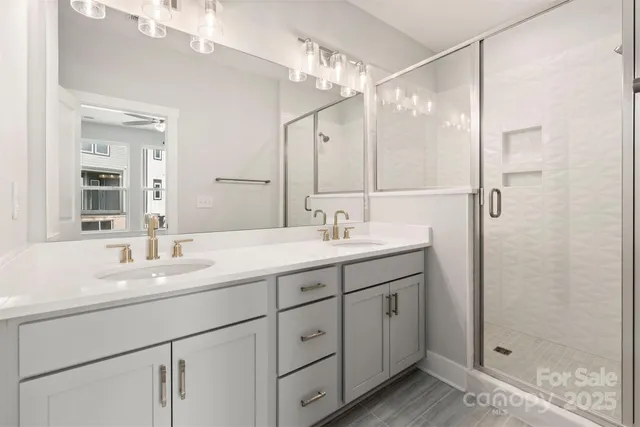 a bathroom with a double vanity sink mirror and shower