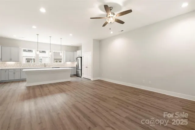 a large white kitchen with a white countertops with wooden floor