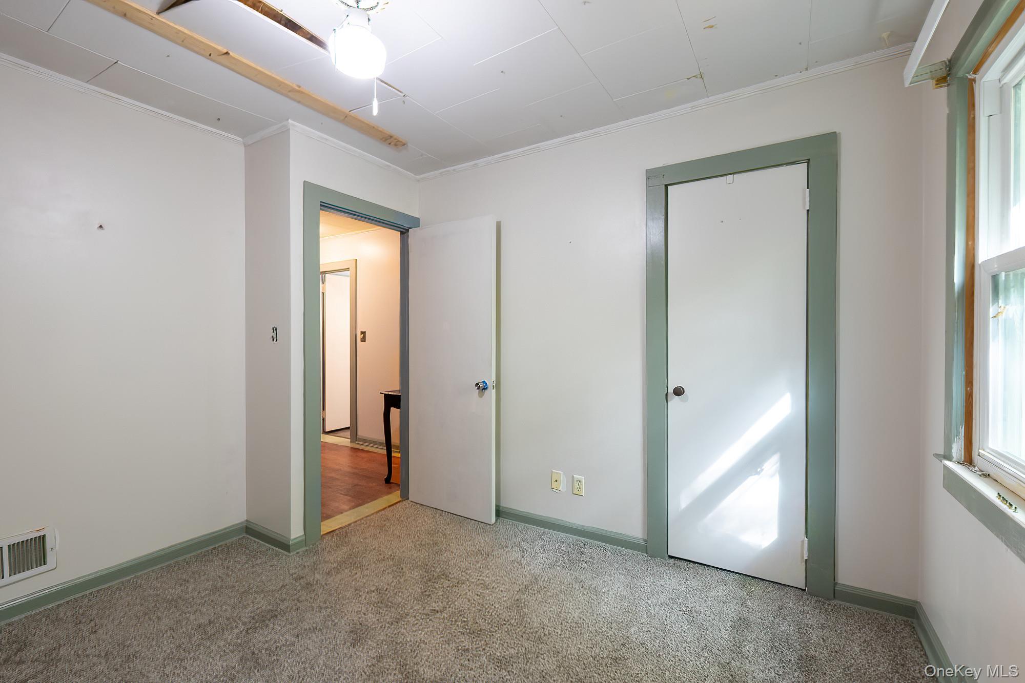 240 Stevers Crossing Road Hudson, NY 12534 - Photo 11 of 21 Unfurnished bedroom featuring carpet flooring, ornamental molding, multiple windows, and a closet