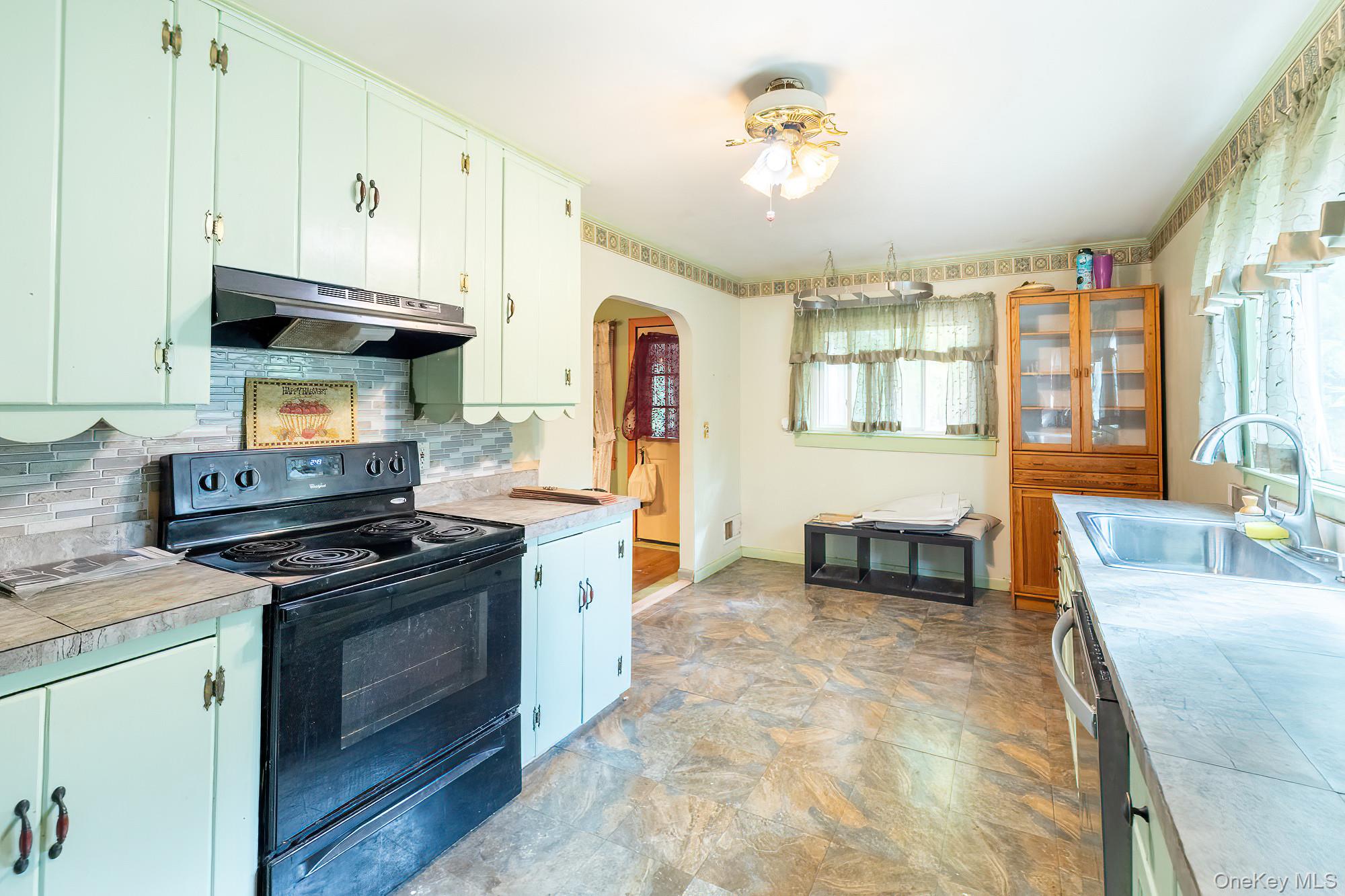 240 Stevers Crossing Road Hudson, NY 12534 - Photo 2 of 21 Kitchen featuring black electric range, under cabinet range hood, healthy amount of natural light, and light countertops