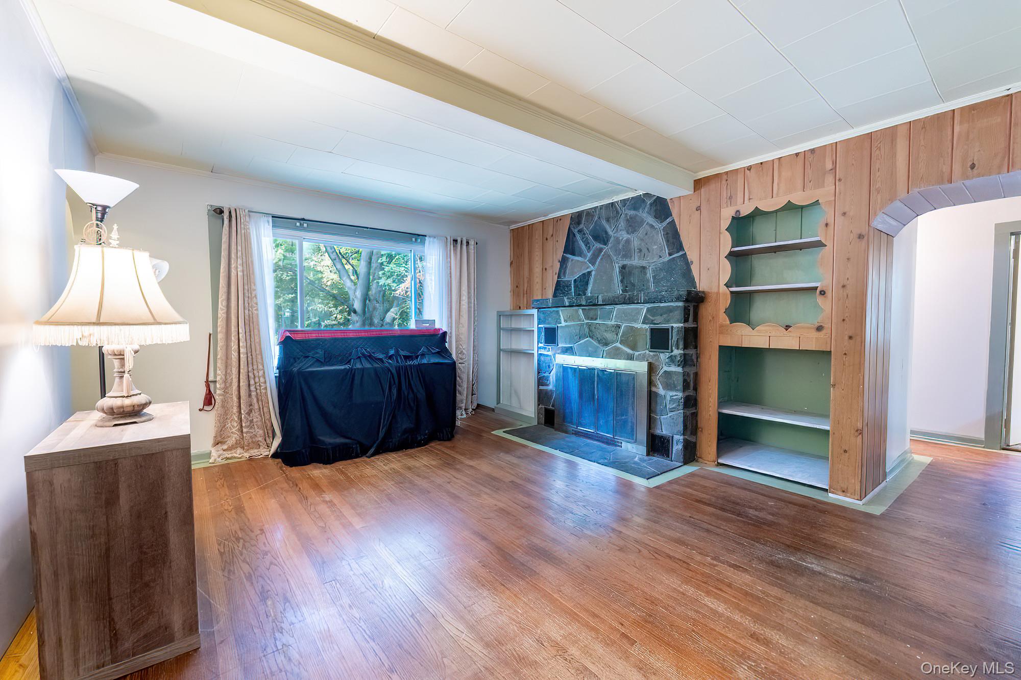 240 Stevers Crossing Road Hudson, NY 12534 - Photo 6 of 21 Living area featuring wood walls, wood finished floors, beam ceiling, and a fireplace