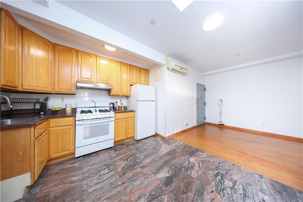 2265 West 7th Street, Unit 3B Brooklyn, NY 11223 - Photo 11 of 17 a kitchen with stainless steel appliances granite countertop a stove a sink and a refrigerator