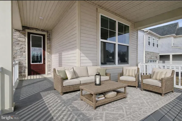 a view of a patio with couches and a dining table and chairs with wooden floor