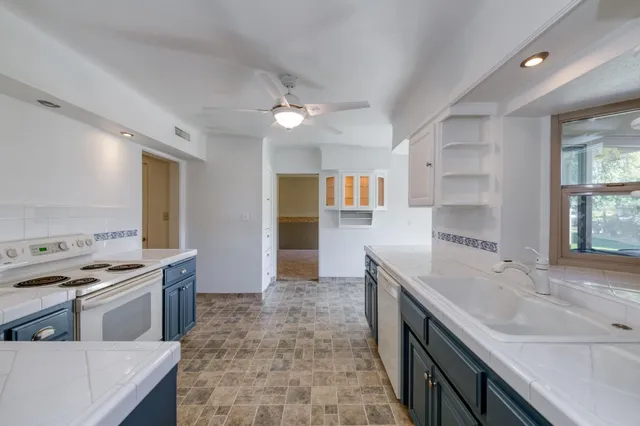 a kitchen with stainless steel appliances granite countertop a sink a stove and a refrigerator
