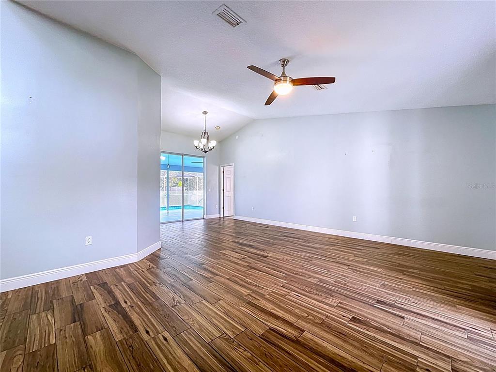 18812 Bascomb Lane Hudson, FL 34667 - Photo 18 of 57 wooden floor in an empty room with a window