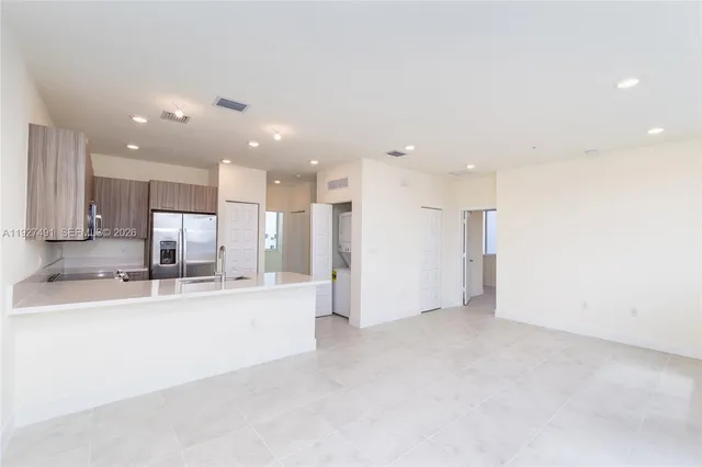 a view of kitchen with kitchen island and stainless steel appliances