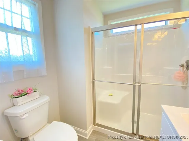 a white toilet sitting next to a bathroom next to a window