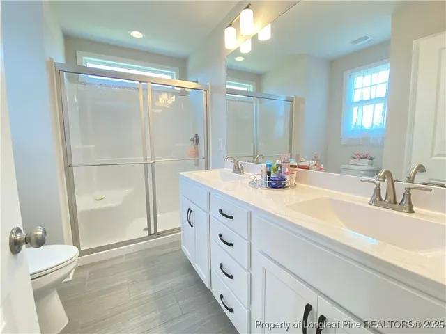 a bathroom with a double vanity sink mirror double and shower