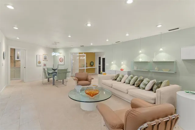 a living room with furniture a floor to ceiling window and floor to ceiling window