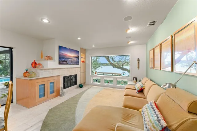 a living room with furniture kitchen view and a large window