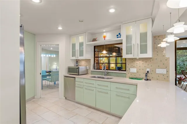 a kitchen with kitchen island stainless steel appliances cabinets a sink and a counter top space
