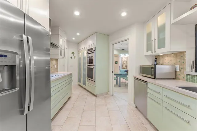 a kitchen with sink and view of living room