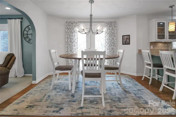 a kitchen with kitchen island granite countertop a sink cabinets and wooden floor