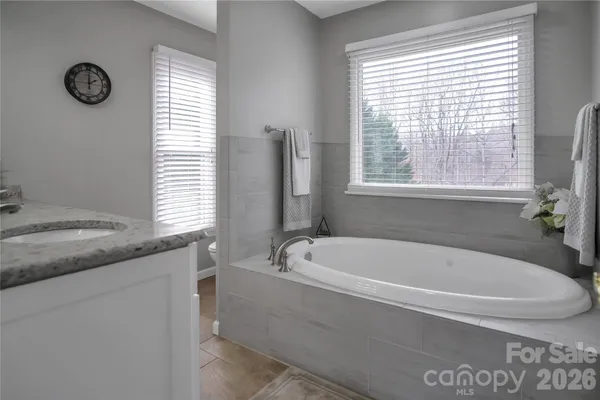 a bathroom with a granite countertop sink a mirror and a shower