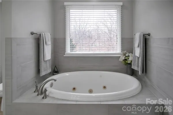a bathroom with a granite countertop tub sink and mirror
