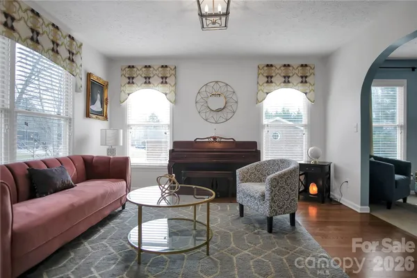 a living room with furniture a fireplace and a large mirror