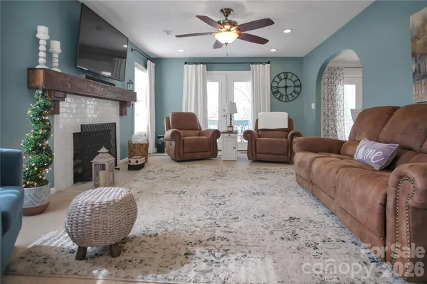 a living room with furniture a fireplace and a large window
