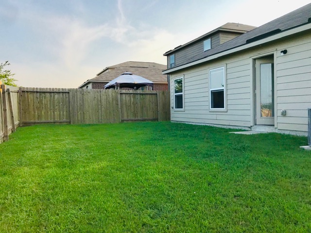 20105 Grover Cleveland Way Manor, TX 78653 - Photo 15 of 17 A well-maintained fenced yard offers a private outdoor haven behind this inviting home.