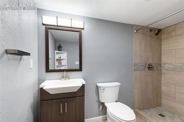 4540 Sierra Rica Road Colorado Springs, CO 80911 - Photo 35 of 42 Bathroom with a textured wall, vanity, and a stall shower