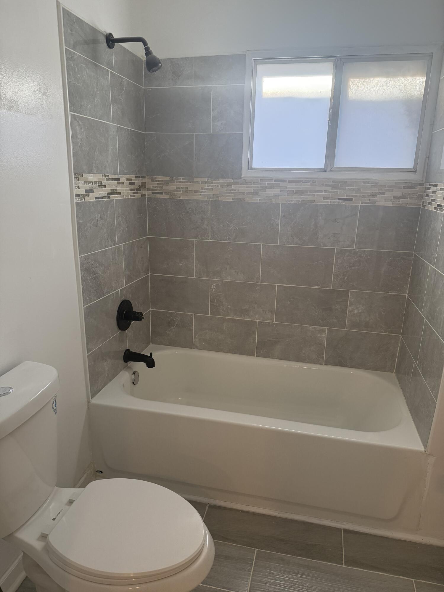 634 Kentucky Street Gary, IN 46402 - Photo 14 of 18 a white toilet and tub sitting next to a bathroom sink