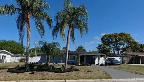 a front view of a house with palm trees