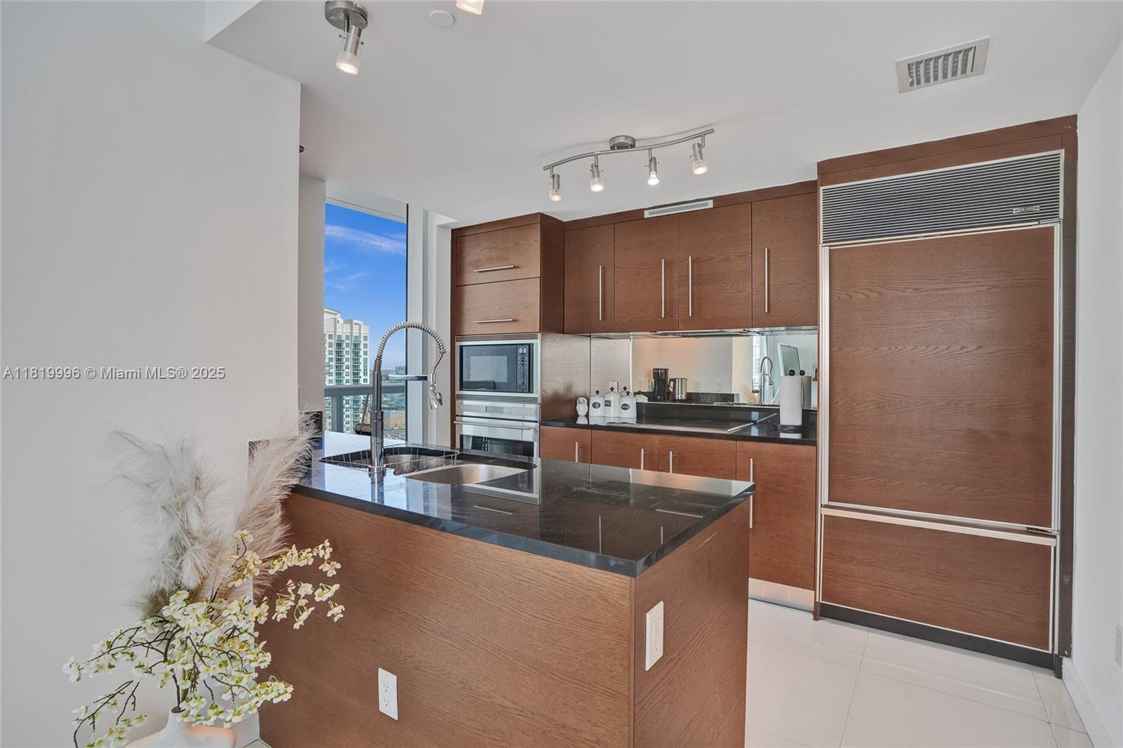 485 Brickell Avenue, Unit 3608 Miami, FL 33131 - Photo 6 of 43 a kitchen with stainless steel appliances granite countertop a refrigerator a stove and a sink with wooden floor