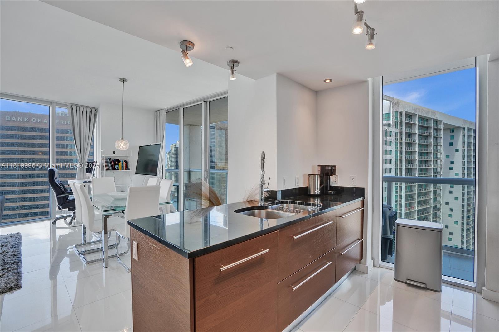 485 Brickell Avenue, Unit 3608 Miami, FL 33131 - Photo 8 of 43 a kitchen with kitchen island granite countertop a stove and a view of living room