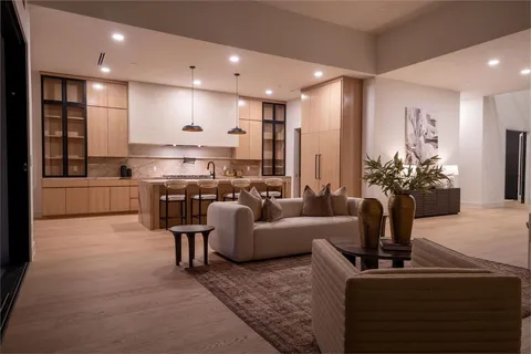 a living room with furniture kitchen view and a potted plant