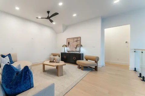 a view of room with wooden floor and a ceiling fan