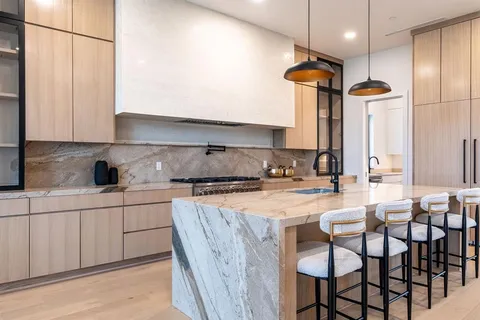 a kitchen with stainless steel appliances granite countertop a sink and a refrigerator