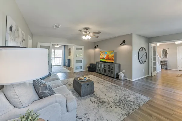 a living room with furniture and a wooden floor