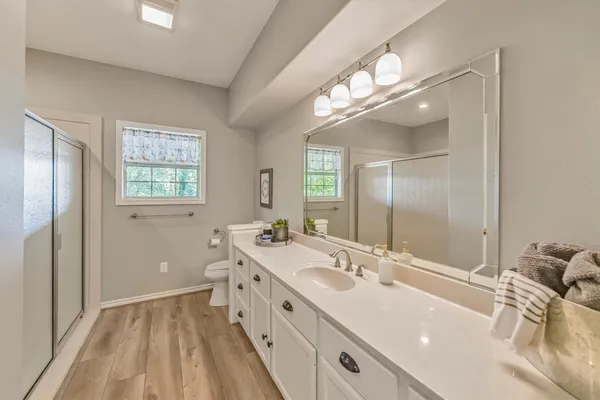 a bathroom with a double vanity sink and mirror with shower