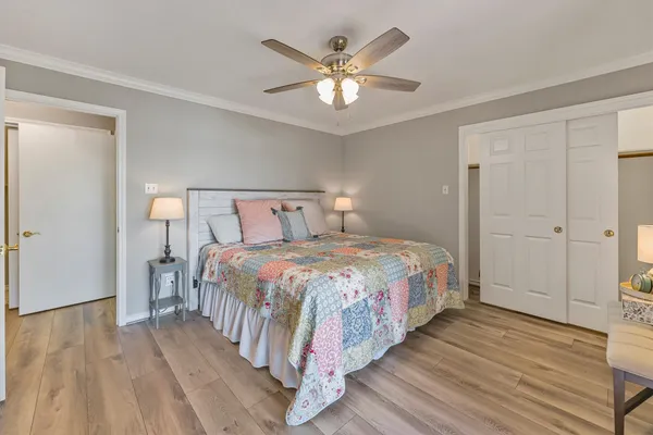 a bedroom with a large bed and a ceiling fan