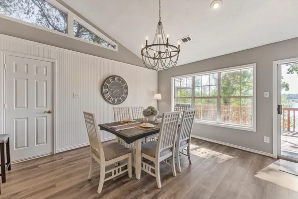 a view of a dining room with furniture a chandelier and wooden floor