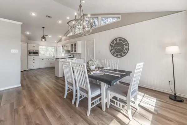 a view of a dining room with furniture a chandelier and wooden floor