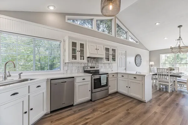 a kitchen with sink stove and cabinets