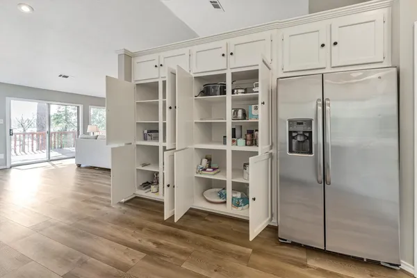 a walk in closet with wooden floor and windows