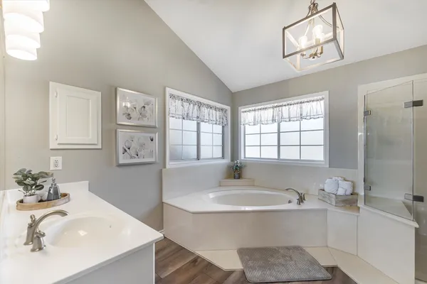 a bathroom with a tub sink and mirror