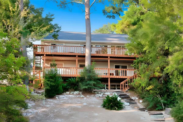 a front view of a house with plants and trees