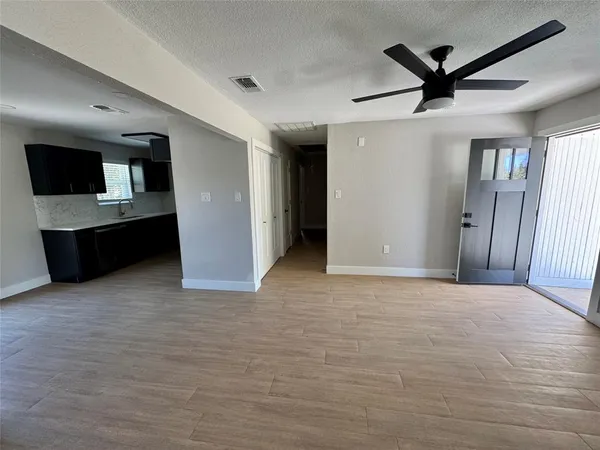 a view of a livingroom with a ceiling fan and wooden floor