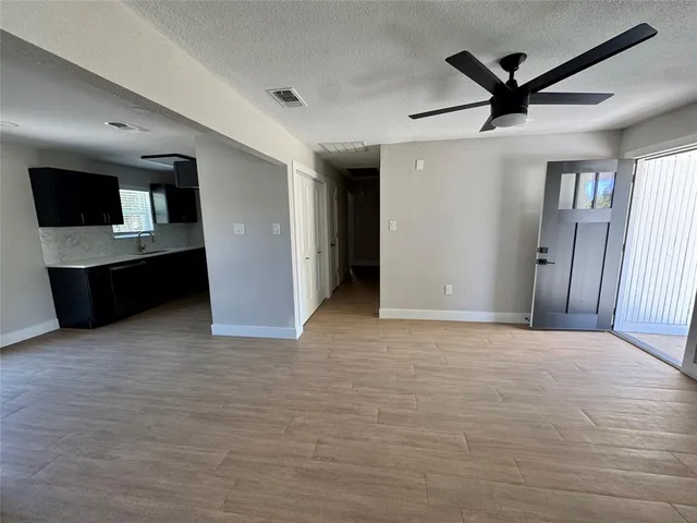a view of a livingroom with a ceiling fan and wooden floor