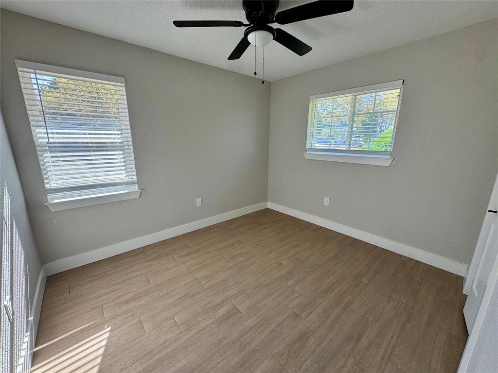 3824 Patman Street Lancaster, TX 75134 - Photo 16 of 24 a view of an empty room with wooden floor and a window