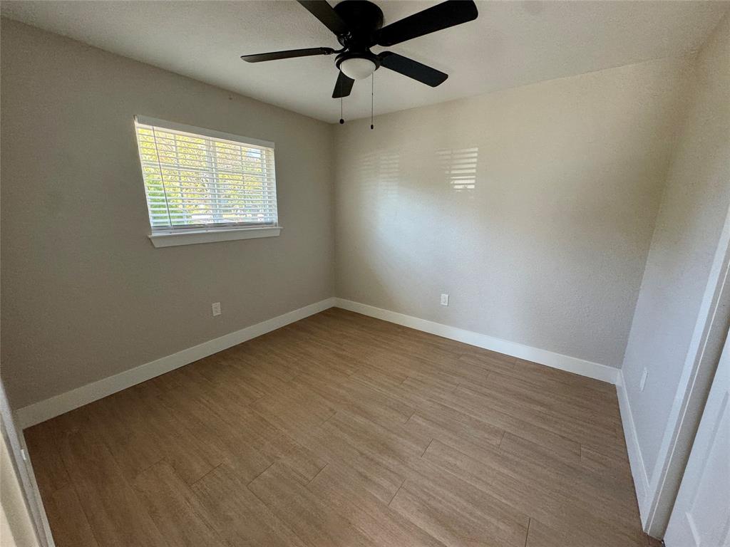 3824 Patman Street Lancaster, TX 75134 - Photo 19 of 24 an empty room with wooden floor fan and windows