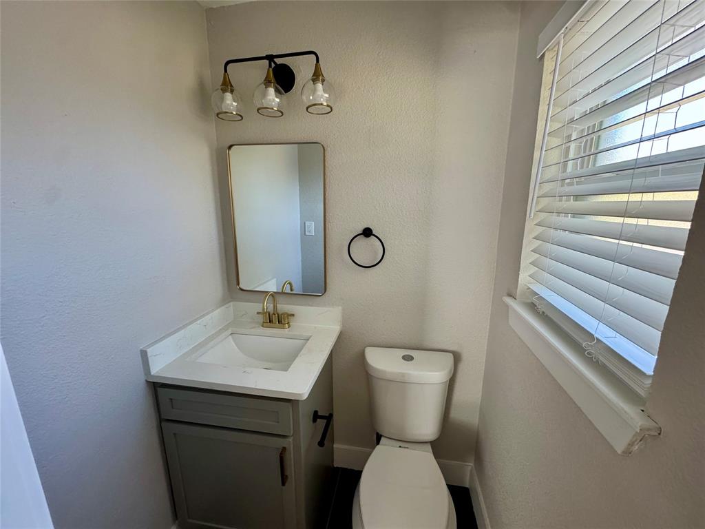 3824 Patman Street Lancaster, TX 75134 - Photo 22 of 24 a bathroom with a toilet sink and mirror